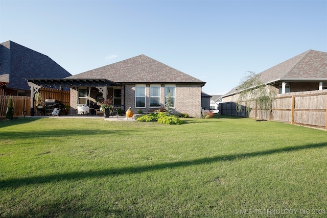 back of house with a pergola and a yard