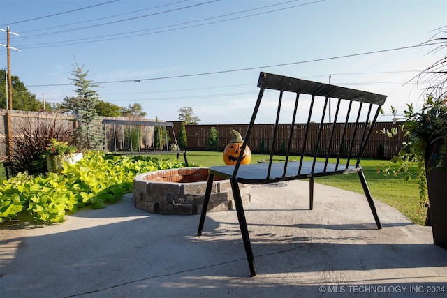 view of jungle gym with a yard, a patio, and an outdoor fire pit