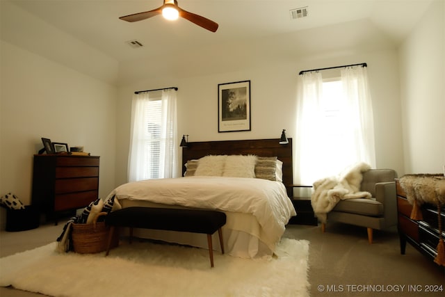 bedroom featuring light carpet, vaulted ceiling, multiple windows, and ceiling fan