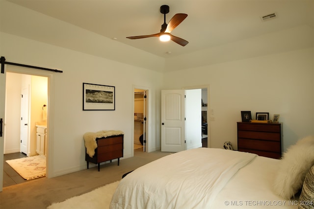 carpeted bedroom featuring ensuite bathroom, ceiling fan, a barn door, a spacious closet, and a closet