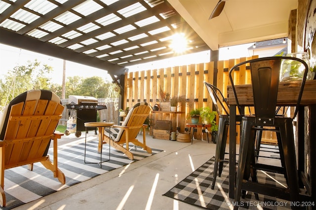 view of patio featuring ceiling fan, area for grilling, and a pergola