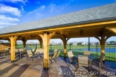 view of property's community featuring a gazebo, a water view, and a patio area