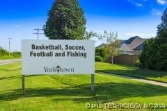 community sign featuring a yard