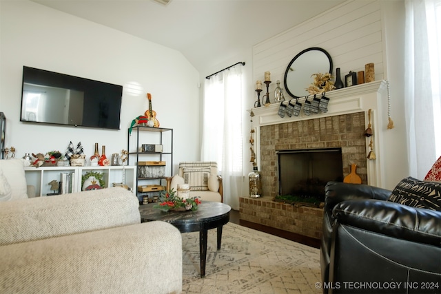 living room featuring a fireplace, lofted ceiling, and light wood-type flooring