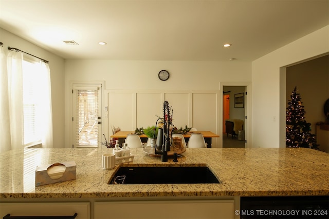 kitchen with light stone counters and sink