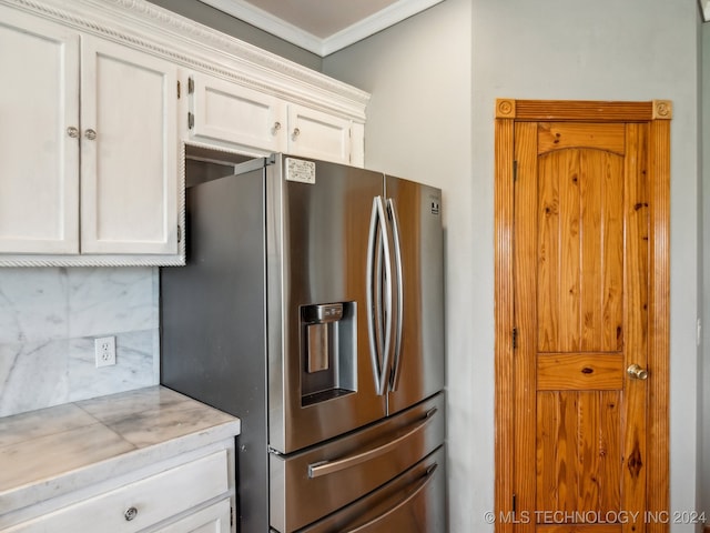 kitchen featuring stainless steel fridge with ice dispenser, crown molding, white cabinetry, and tasteful backsplash