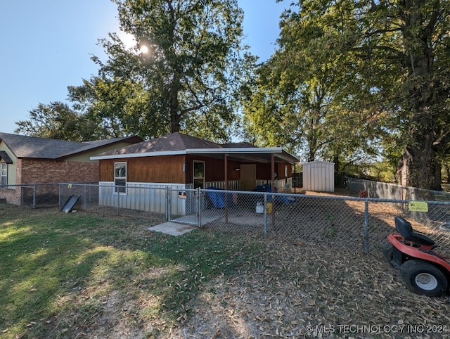 back of house featuring a lawn and a storage unit