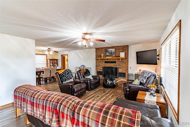 living room with hardwood / wood-style flooring, a fireplace, and a textured ceiling