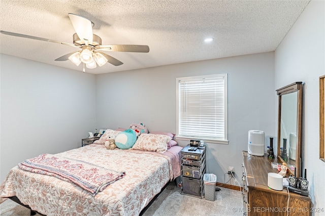 carpeted bedroom with ceiling fan and a textured ceiling