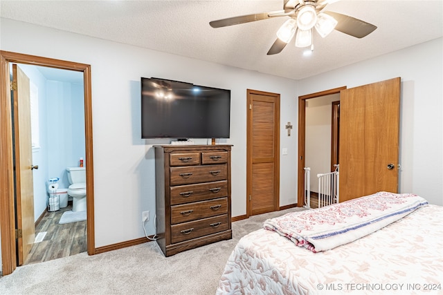 bedroom featuring ceiling fan, connected bathroom, a textured ceiling, a closet, and light colored carpet