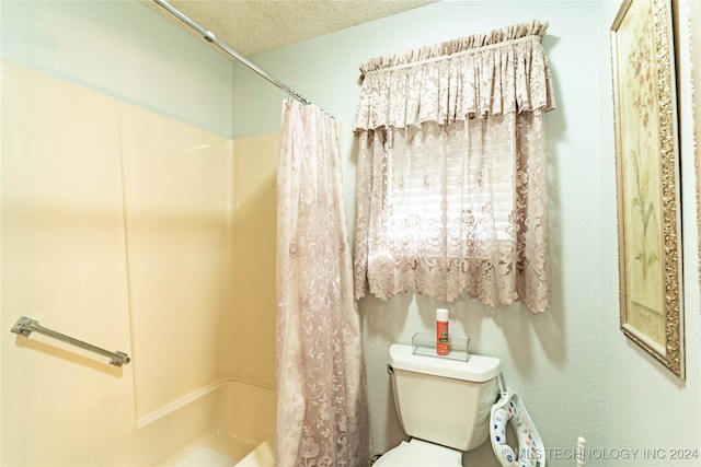 bathroom featuring shower / tub combo, a textured ceiling, and toilet