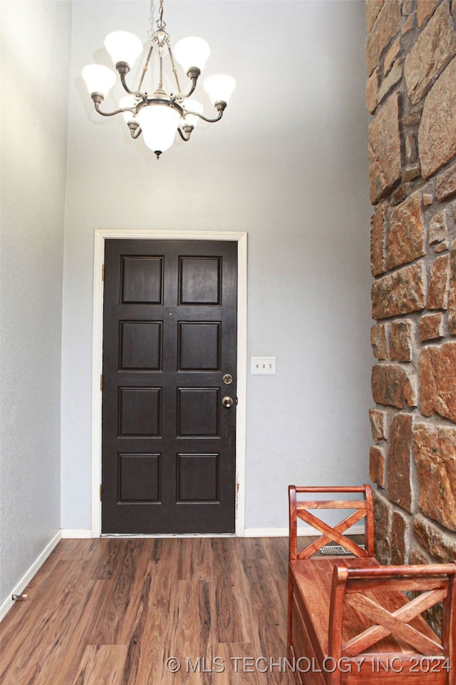 foyer entrance with dark hardwood / wood-style flooring and a chandelier