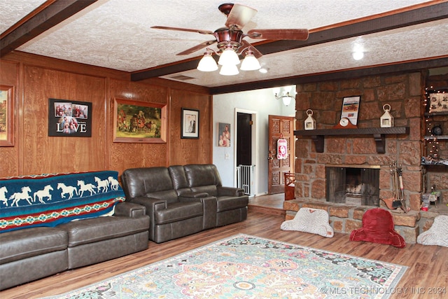 living room with beam ceiling, hardwood / wood-style floors, and a textured ceiling