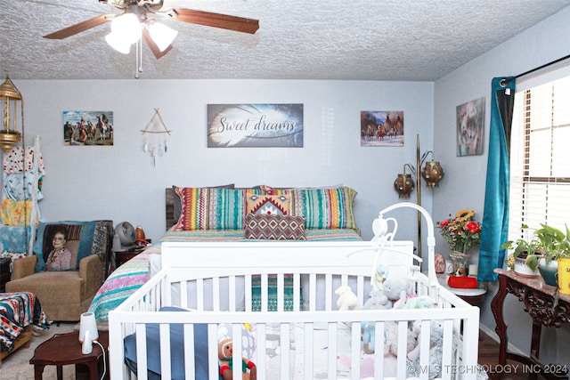 bedroom with ceiling fan and a textured ceiling