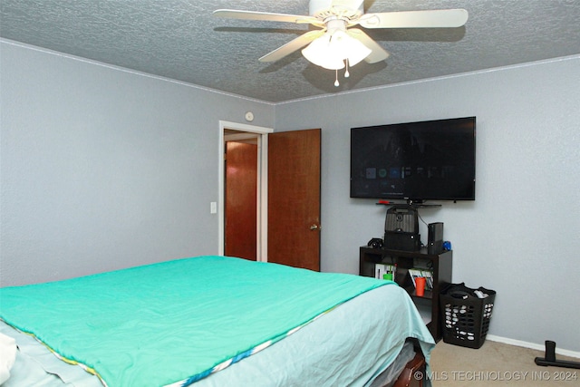 carpeted bedroom featuring ceiling fan and a textured ceiling