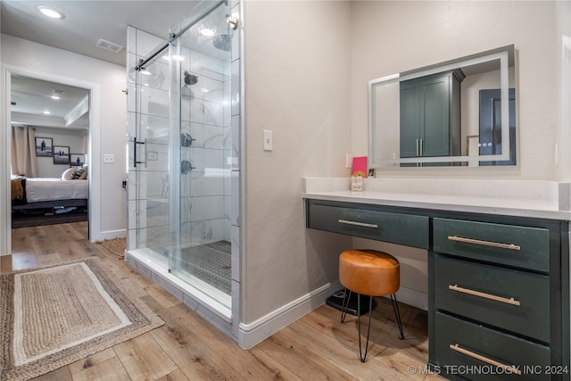 bathroom featuring vanity, an enclosed shower, and wood-type flooring