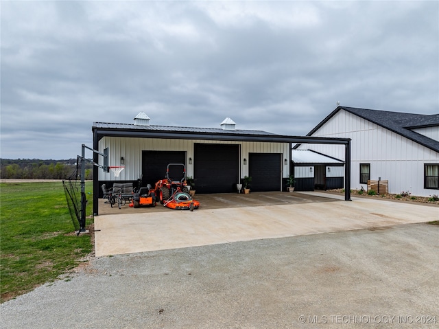 garage featuring wood walls, a lawn, and a carport