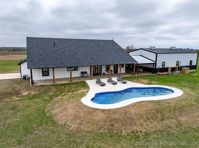 view of pool featuring a lawn and a patio area