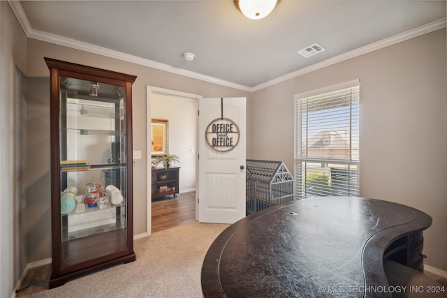 dining room featuring ornamental molding and light colored carpet