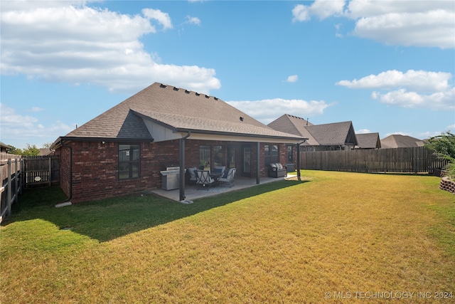 rear view of house with a patio and a lawn