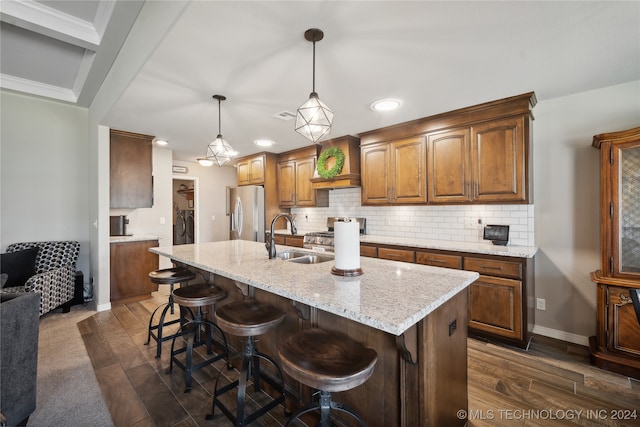 kitchen with dark hardwood / wood-style flooring, independent washer and dryer, sink, hanging light fixtures, and appliances with stainless steel finishes