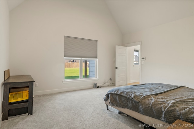 carpeted bedroom with high vaulted ceiling