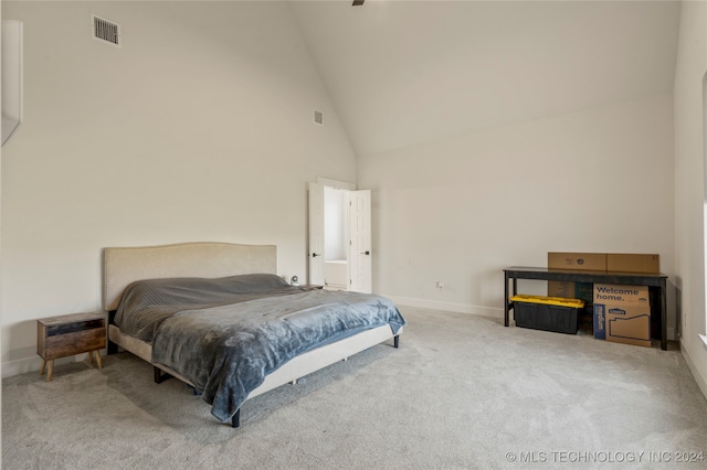 carpeted bedroom with high vaulted ceiling