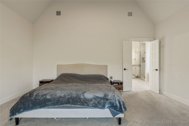 bedroom with light colored carpet and high vaulted ceiling