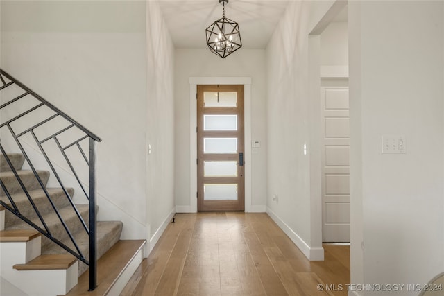 foyer featuring an inviting chandelier and light hardwood / wood-style flooring