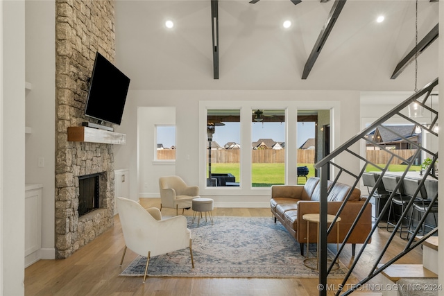 interior space featuring ceiling fan, vaulted ceiling with beams, and a fireplace