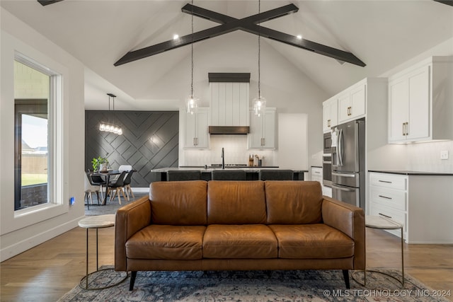 living room featuring beamed ceiling, hardwood / wood-style floors, a chandelier, and high vaulted ceiling