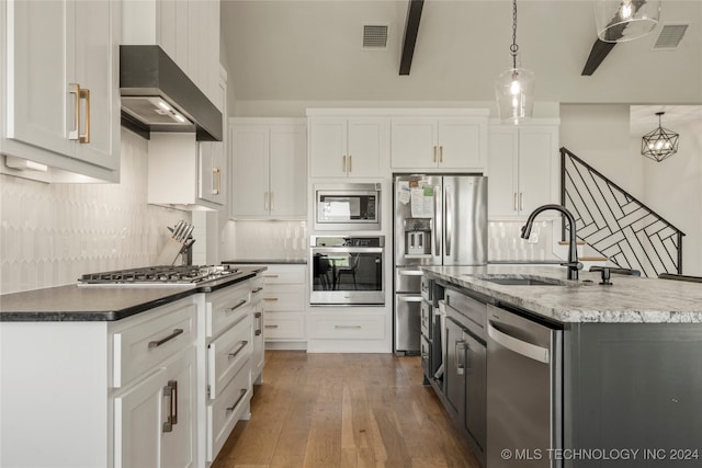 kitchen featuring appliances with stainless steel finishes, hanging light fixtures, and white cabinets