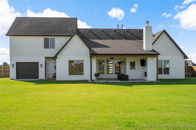 back of property featuring ceiling fan, a garage, a lawn, and a patio