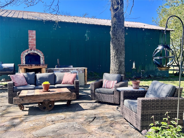 view of patio featuring an outdoor living space with a fireplace and grilling area