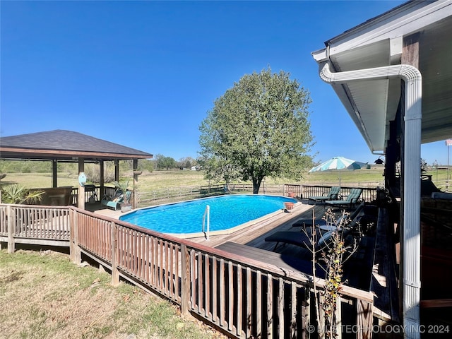 view of pool with a wooden deck and a yard