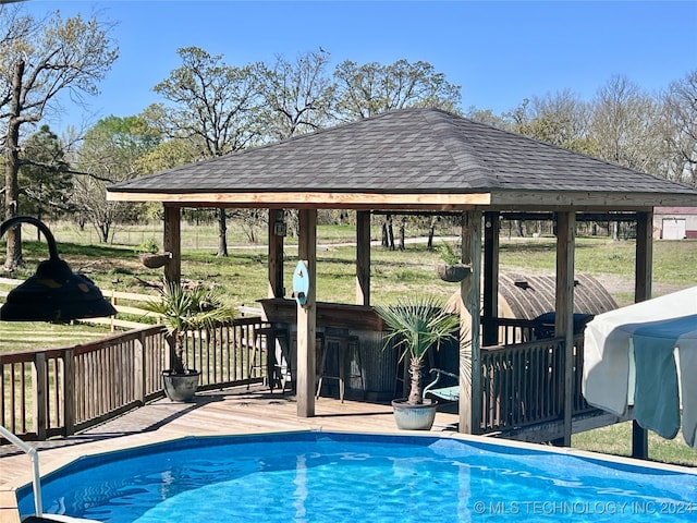 view of pool with a gazebo and a wooden deck