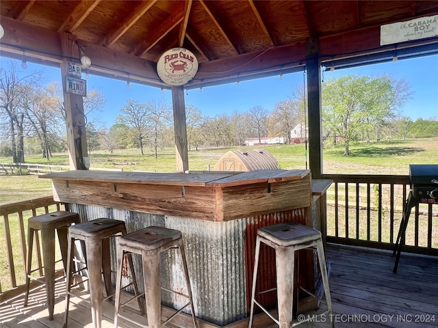 wooden terrace with a yard and exterior bar