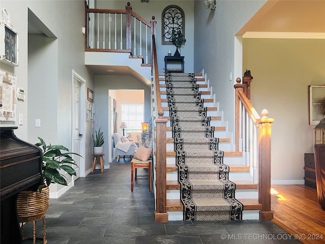 staircase with hardwood / wood-style flooring and ornamental molding