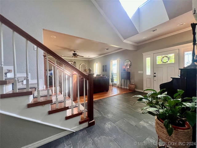 entryway with ceiling fan, a skylight, crown molding, and dark wood-type flooring