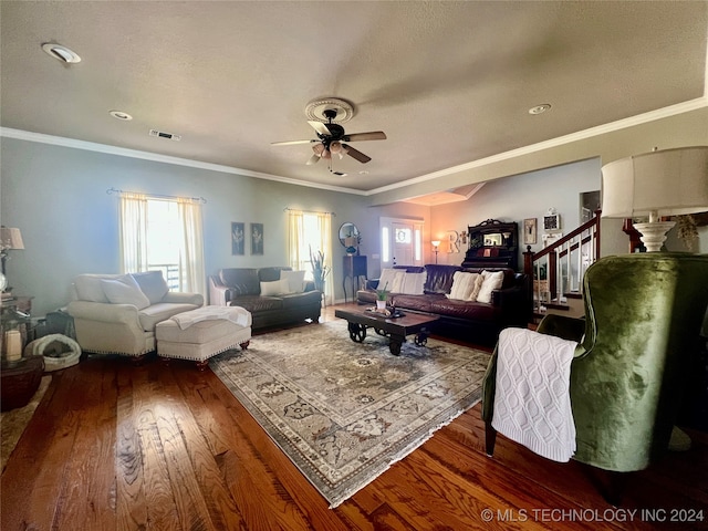 living room with dark wood-type flooring, ornamental molding, and ceiling fan