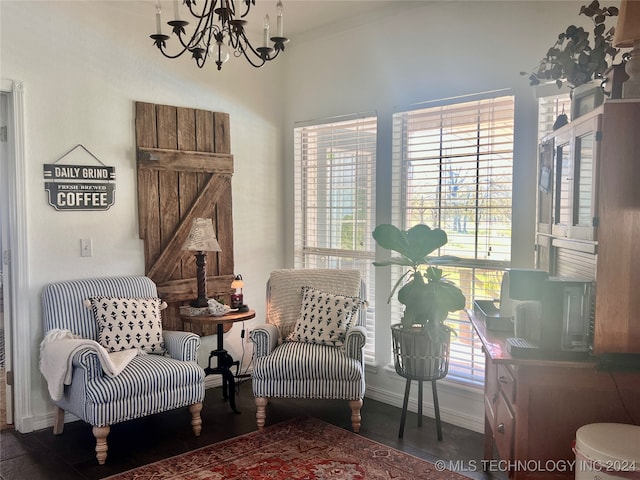 sitting room featuring a barn door, dark hardwood / wood-style floors, an inviting chandelier, and a wealth of natural light