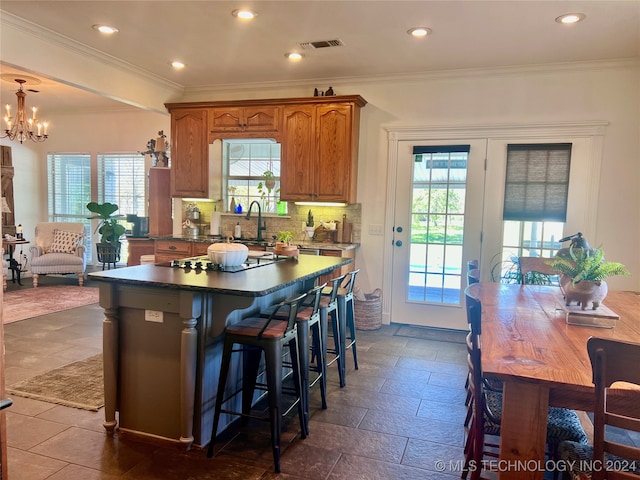 kitchen featuring a center island, backsplash, crown molding, and a healthy amount of sunlight