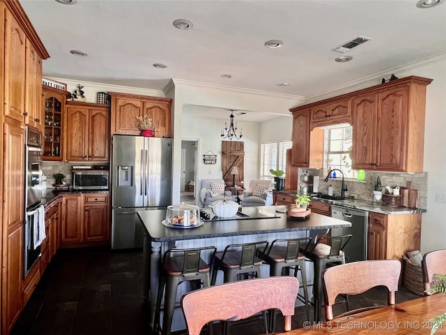 kitchen with stainless steel appliances, tasteful backsplash, sink, and a kitchen breakfast bar