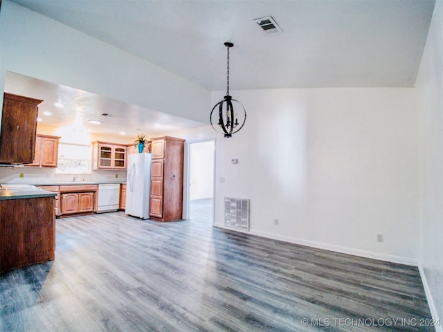 kitchen featuring white appliances, vaulted ceiling, a notable chandelier, sink, and dark hardwood / wood-style floors