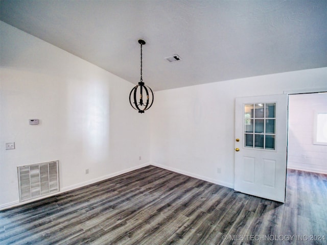 unfurnished dining area with vaulted ceiling, a notable chandelier, and dark hardwood / wood-style flooring