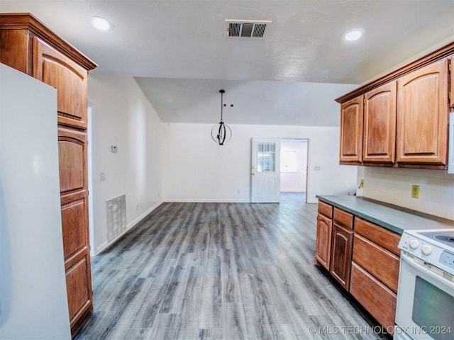 kitchen with tasteful backsplash, hardwood / wood-style flooring, white appliances, an inviting chandelier, and decorative light fixtures