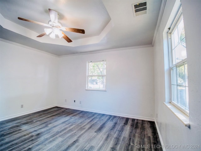 spare room featuring a tray ceiling, dark hardwood / wood-style floors, crown molding, and ceiling fan