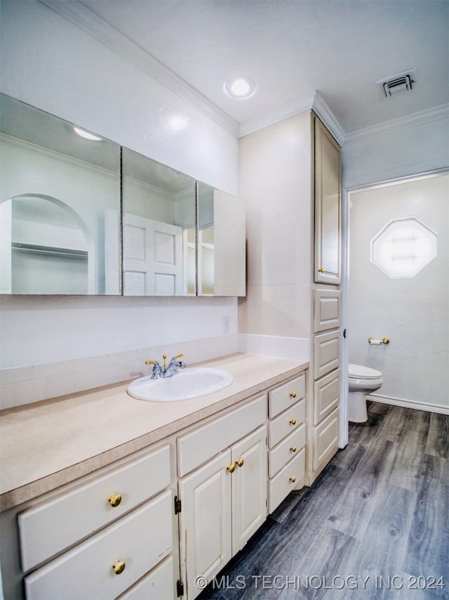 bathroom featuring vanity, crown molding, toilet, and hardwood / wood-style flooring