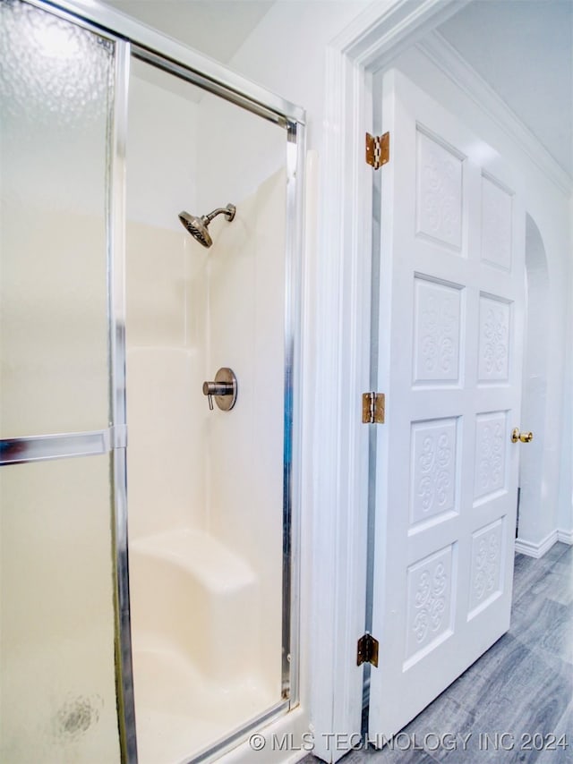 bathroom with an enclosed shower and wood-type flooring