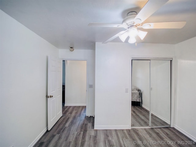 unfurnished bedroom with a closet, dark hardwood / wood-style flooring, and ceiling fan